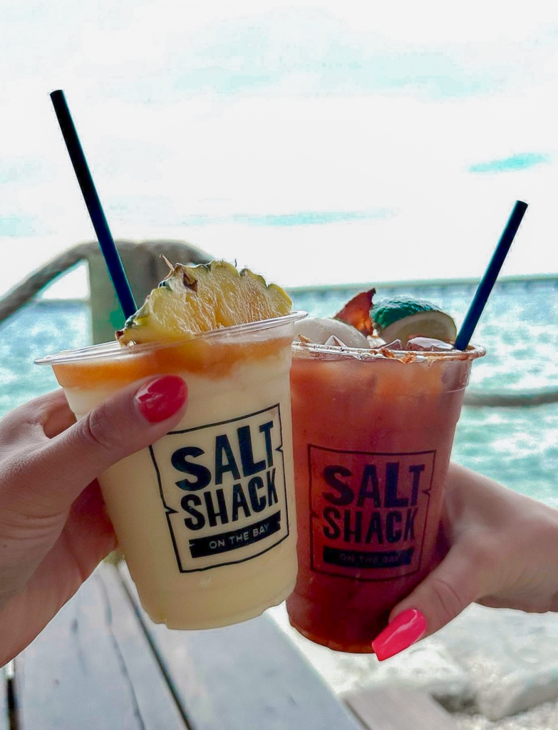 Two cocktails cheers in front of the ocean